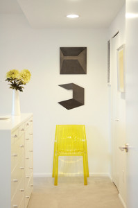 A yellow polycarbonate chair from Projects Contemporary Furniture  in Des Moines and steel reliefs from German artist Heiner Thiel add interest to the bedroom.