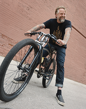 Dan Koenig shows off one of his custom-made electric bicycles, which are powered by a small battery-driven motor. 