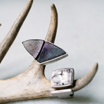 Rings like these show why Marisa Adamson thinks of her jewelry as “mini-sculptures.” On the left, purple and black druzy tourmaline quartz is formed into a triangle. The ring on the right is made out of palladium with white diamonds and platinum valley agate.