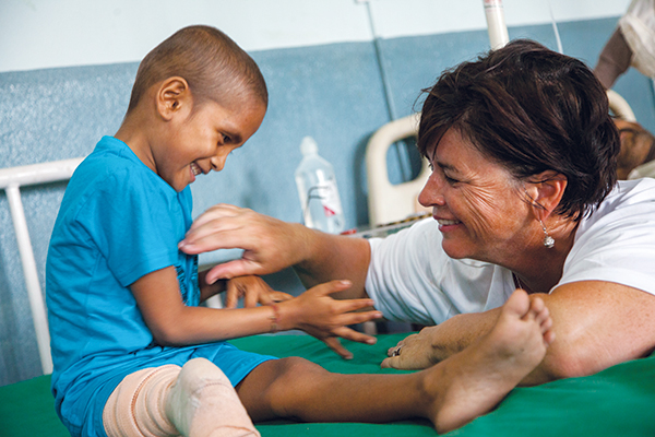 Kelly Danoto of Des Moines, a cancer survivor and nurse, engages a hospitalized Nepali child whose bone cancer preceded the earthquake that broke his leg. “He was shy at first,” says photographer Dylan Huey, “but he warmed up quickly.” Cancer carries a stigma among many in Nepal, who may shun the afflicted as contagious or unclean, Huey says.