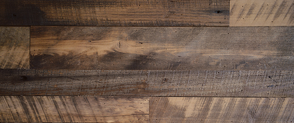 Lightly planed oak planks, remnants of some long-gone country barn, give this wall an intriguing variety of colors and patterns apart from the natural wood grain. Knotholes just add character; the underlying drywall is painted dark, so the holes and gaps have a mysterious air.