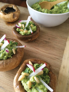 Raw mushroom caps, marinated in a vinaigrette, make an easy appetizer. Fill with guacamole and top with nuts and radish sticks.